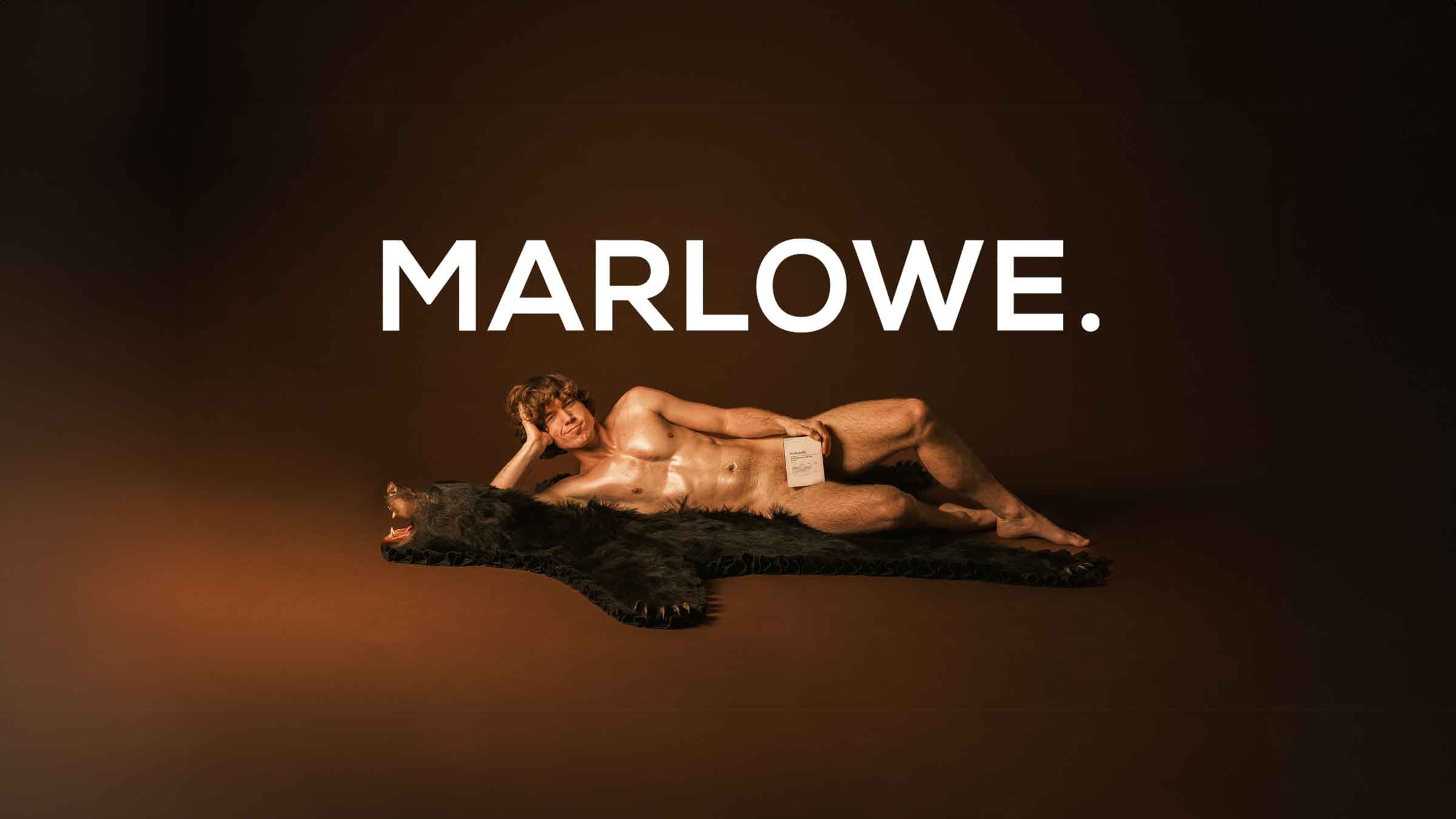 Danny Duncan on bear skin rug holding MARLOWE. Skin products with MARLOWE. Logo