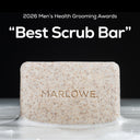 MARLOWE cedarwood and sea salt scrub soap bar with an award plaque in the background, showcasing a natural, textured soap product.